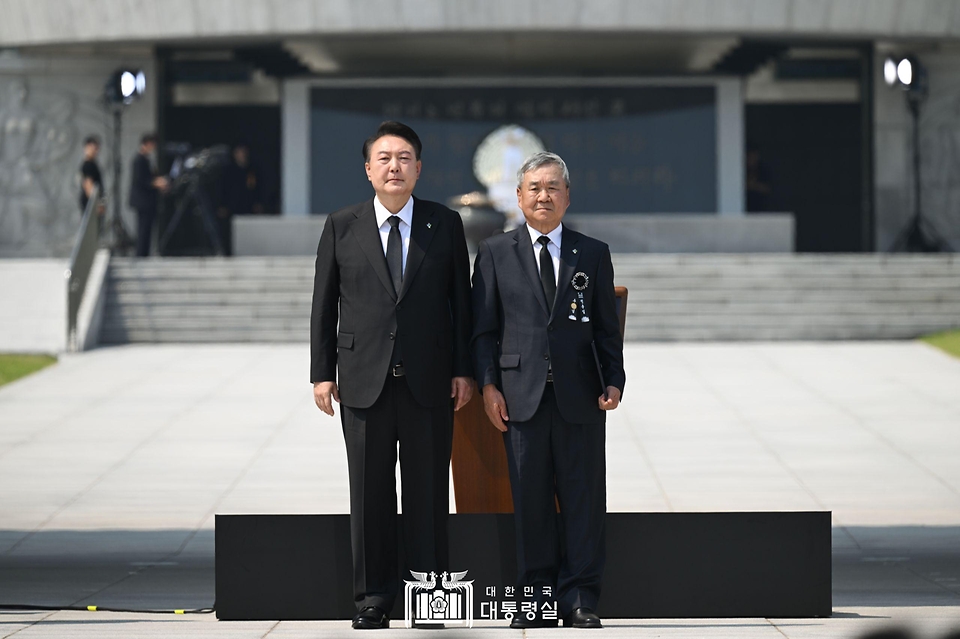 윤석열 대통령이 6일 서울 동작구 국립서울현충원에서 열린 ‘제69회 현충일 추념식’에서 6.25 참전 무공수훈자인 고 김중태 하사의 유족에게 국가유공자 증서를 수여한 뒤 기념 촬영을 하고 있다. 