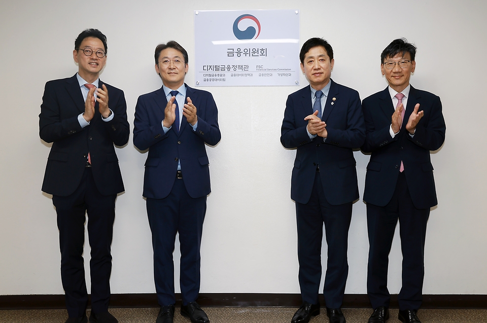 김주현 금융위원장이 25일 오후 서울 종로구 정부서울청사에서 디지털금융정책관 정규화 및 가상자산과 신설을 기념하는 현판식을 하고 있다.