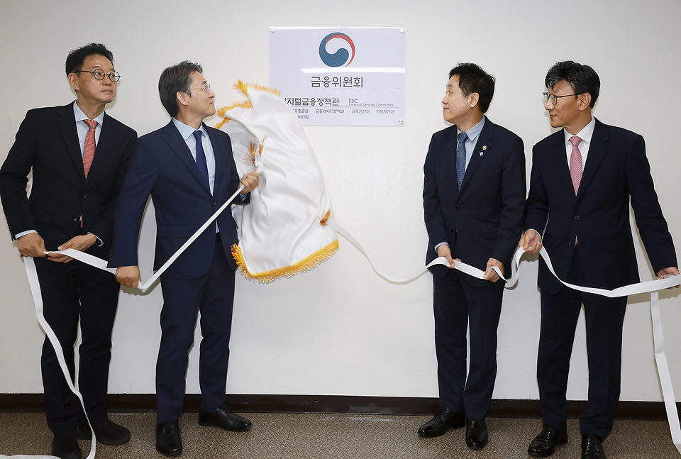 김주현 금융위원장이 25일 오후 서울 종로구 정부서울청사에서 디지털금융정책관 정규화 및 가상자산과 신설을 기념하는 현판식을 하고 있다.