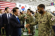 윤석열 대통령이 25일 부산 해군작전기지에서 미 해군 항공모함 시어도어 루즈벨트함에 승선해 발언 뒤 한미 장병들과 인사하며 이동하고 있다. 