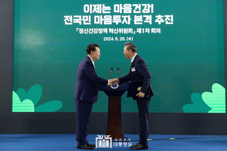 윤석열 대통령이 26일 서울 광진구 보건복지부 국립정신건강센터에서 열린 ‘정신건강정책 혁신위원회 1차 회의’에서 정신건강정책 혁신위원장인 신영철 강북삼성병원 정신건강의학과 교수에게 민간위원 위촉장을 수여하고 있다. 