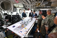 윤석열 대통령이 25일 부산 해군작전기지에서 미 해군 항공모함 시어도어 루즈벨트함에 승선해 비행갑판 통제실에서 브라이언 스크럼 루즈벨트 함장으로부터 항모에 대한 설명을 듣고 있다.
