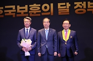 한덕수 국무총리(가운데)가 27일 서울 중구 한 호텔에서 열린 호국보훈의 달 정부포상식에서 김기병 롯데관광개발 대표이사 회장(오른쪽)에게 국민훈장 모란장을 전달한 뒤 기념 촬영하고 있다.