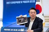 윤석열 대통령이 3일 서울 종로구 청와대 영빈관에서 열린 ‘하반기 경제정책방향 및 역동경제 로드맵 발표’ 회의에서 F1 경주의 피트 스톱 사진을 들고 마무리 발언을 하고 있다.