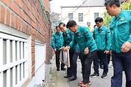 한덕수 국무총리가 11일 서울 마포구 침수취약 주택가를 방문해 침수방지대책을 점검하며 물막이판 장착을 시연하고 있다.