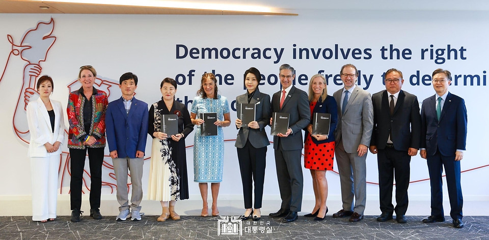 김건희 여사가 11일(현지시간) 미국 워싱턴 D.C. 민주주의진흥재단(NED) 회의실에서 열린 북한인권간담회에서 참석자들과 한국 정부가 발간한 ‘2024 북한인권보고서’를 들고 기념 촬영을 하고 있다. 