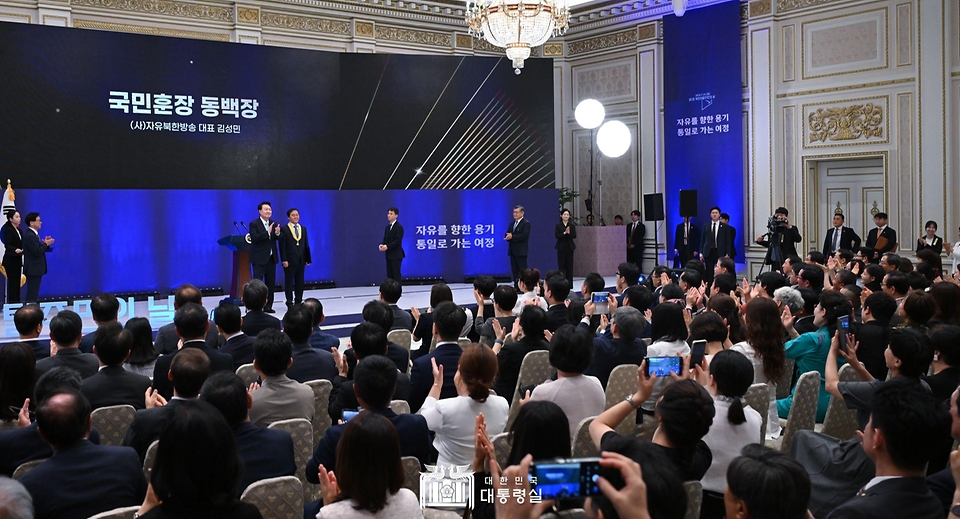 윤석열 대통령이 14일 서울 종로구 청와대 영빈관에서 열린 ‘제1회 북한이탈주민의날 기념식’에서 김성민 자유북한방송대표에게 국민훈장 동백장을 수여하고 있다. 