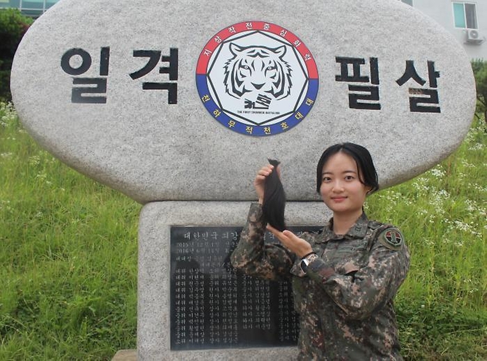 15일 육군지상작전사령부 화력여단 천호대대 고가영 하사가 임관한 뒤 4년 동안 기른  기부할 모발을 들어 보이고 있다. 