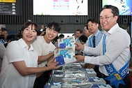 강도형 해수부 장관이 16일 서울 강남구 수서역에서 열린 ‘여름휴가 어촌에서 보내기 캠페인’에서 책과 김을 나눠주고 있다. 
