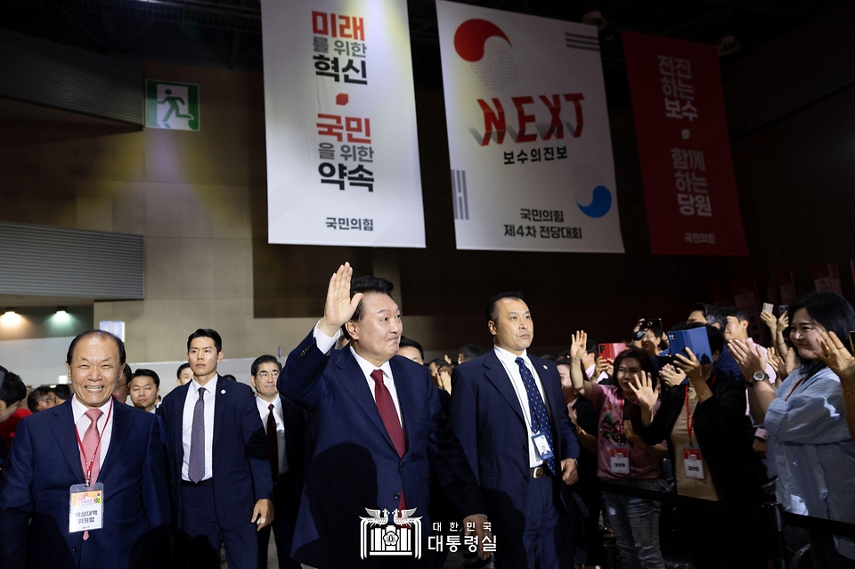 윤석열 대통령이 23일 경기도 고양시 킨텍스에서 열린 ‘국민의힘 제4차 전당대회’에 황우여 비상대책위원장 등과 함께 입장하며 인사하고 있다.