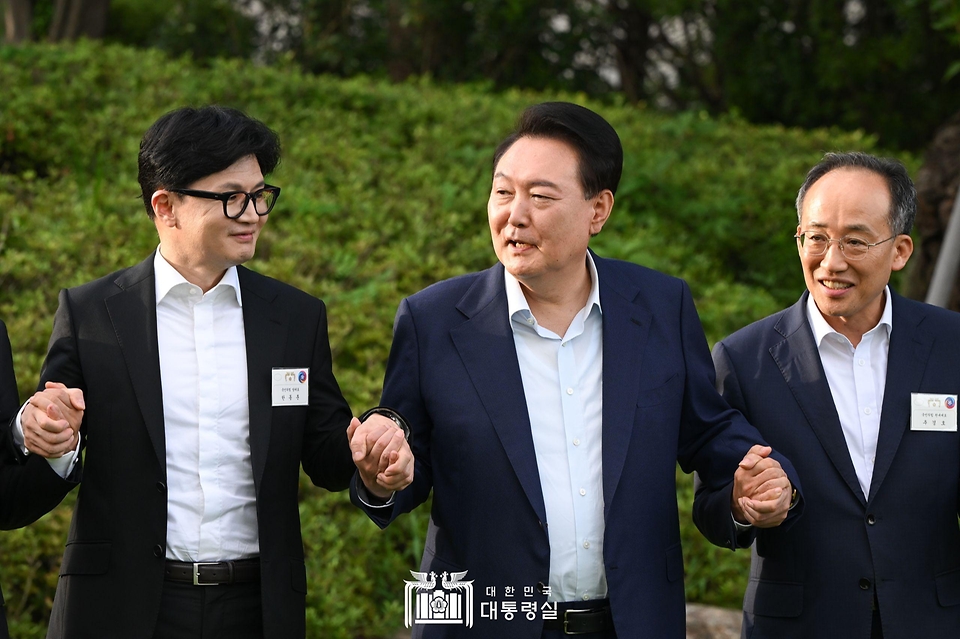 윤석열 대통령이 24일 서울 용산 대통령실 앞 파인그라스에서 열린 국민의힘 신임 지도부 만찬에서 한동훈 대표(왼쪽), 추경호 원내대표(오른쪽) 등과 함께 손을 맞잡고 기념 촬영을 하고 있다.