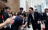 윤석열 대통령이 25일 충남도청에서 열린 ‘제7차 중앙지방협력회의’를 마친 뒤 떠나며 로비에서 도청 직원들과 인사하고 있다.