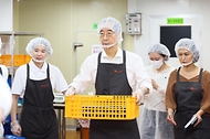 한덕수 국무총리가 8일 서울 성북구 하랑푸드에서 관계자의 안내에 따라 방학 중 결식이 우려되는 아동들을 위한 도시락을 포장 후 들고 이동하고 있다.