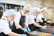 한덕수 국무총리가 8일 서울 성북구 하랑푸드에서 관계자의 안내에 따라 방학 중 결식이 우려되는 아동들을 위한 도시락을 포장하고 있다. 