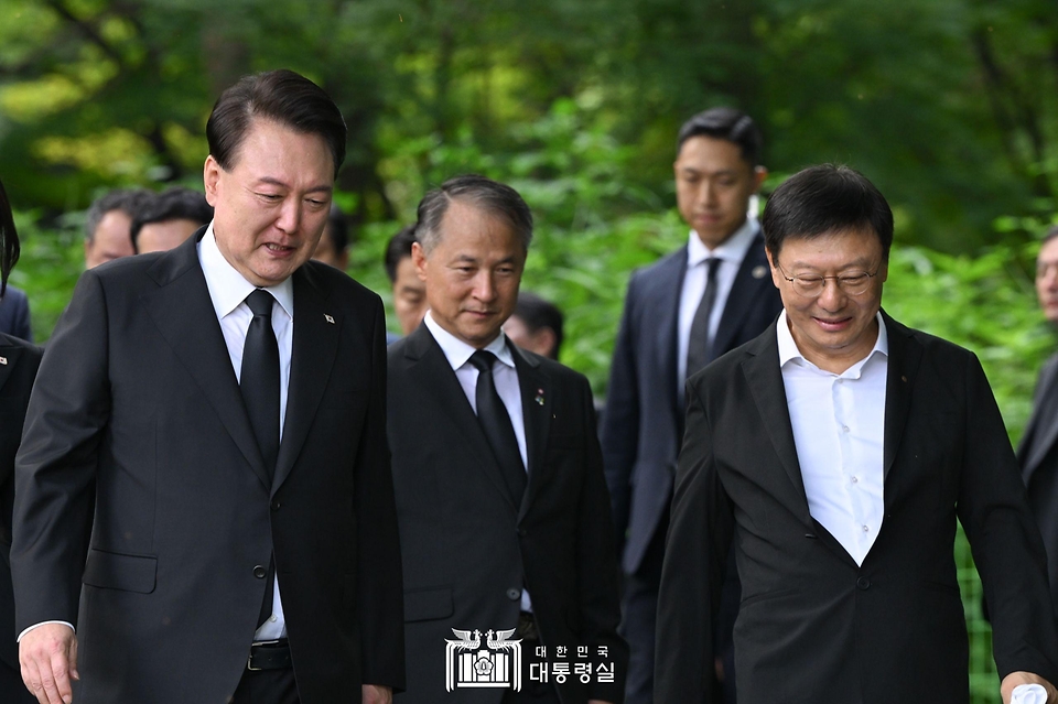 윤석열 대통령이 15일 서울 동작구 국립서울현충원 내 육영수 여사 묘역을 찾아 참배한 뒤 유족인 박지만 회장과 이야기를 나누며 걷고 있다.