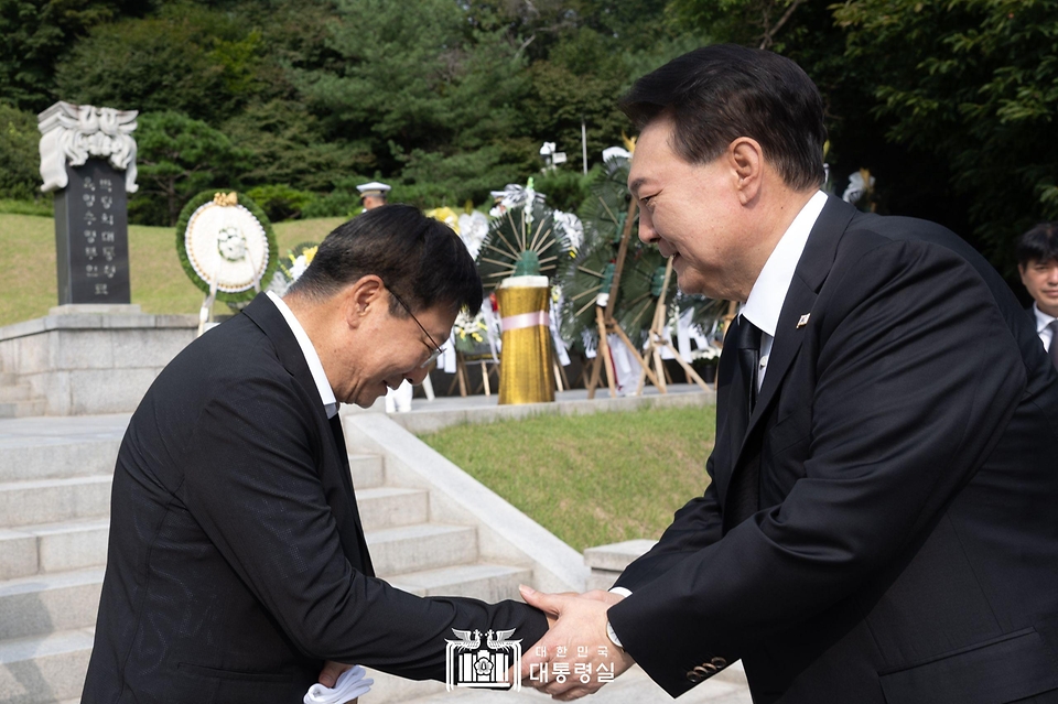 윤석열 대통령이 15일 서울 동작구 국립서울현충원 내 육영수 여사 묘역을 찾아 유족인 박지만 회장과 인사하고 있다. 