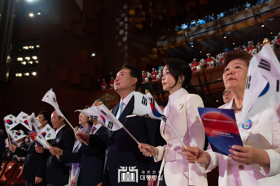 윤석열 대통령과 김건희 여사가 15일 서울 종로구 세종문화회관에서 열린 ‘제79주년 광복절 경축식’에서 태극기를 흔들고 있다.
