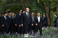 윤석열 대통령이 15일 서울 동작구 국립서울현충원 내 육영수 여사 묘역을 찾아 참배한 뒤 유족인 박지만 회장과 이야기를 나누며 걷고 있다.