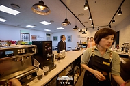 이재명 대통령이 10일 서울 용산 대통령실 청사 구내식당에서 점심 식사를 마친 뒤, 구내 매점에서 출입기자단과 즉석 차담회를 하기 위해 커피를 주문하고 있다.