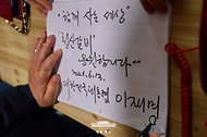 이재명 대통령이 13일 기본소득 실시지역 현황점검을 위해 방문한 경기도 연천군 식당에서 방명록을 남기고 있다.