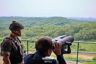 이재명 대통령이 13일 경기도 연천군 육군 25사단 비룡전망대를 방문해 한기성 25사단장의 설명을 들으며 망원경으로 북측을 살펴보고 있다.