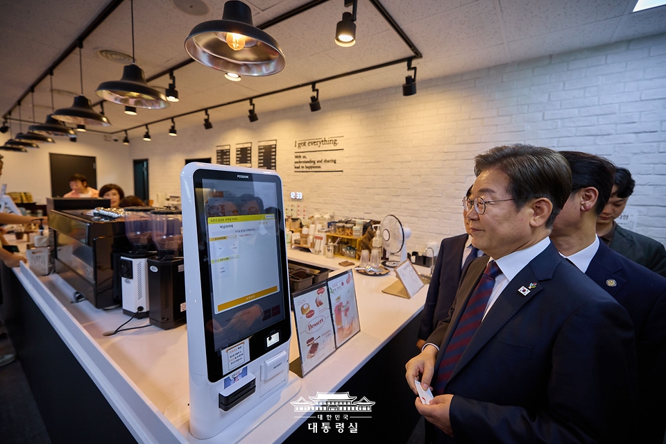 이재명 대통령이 10일 서울 용산 대통령실 청사 구내식당에서 점심 식사를 마친 뒤, 구내 매점에서 출입기자단과 즉석 차담회를 하기 위해 커피를 주문하고 있다.