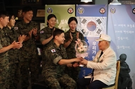 이 대위와 장병들이 박옹에게 꽃다발을 전달하고 있다.