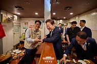 이재명 대통령이 26일 서울 용산 대통령실 앞의 골목 상권인 대구탕집을 찾아 시민과 대화를 하고 있다.
