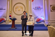 이재명 대통령이 27일 청와대 영빈관에서 열린 '호국 보훈의 달, 대통령의 초대' 행사에서 특별 초청대상자인 이춘자 씨에게 광목이불을 선물한 뒤 박수치고 있다.