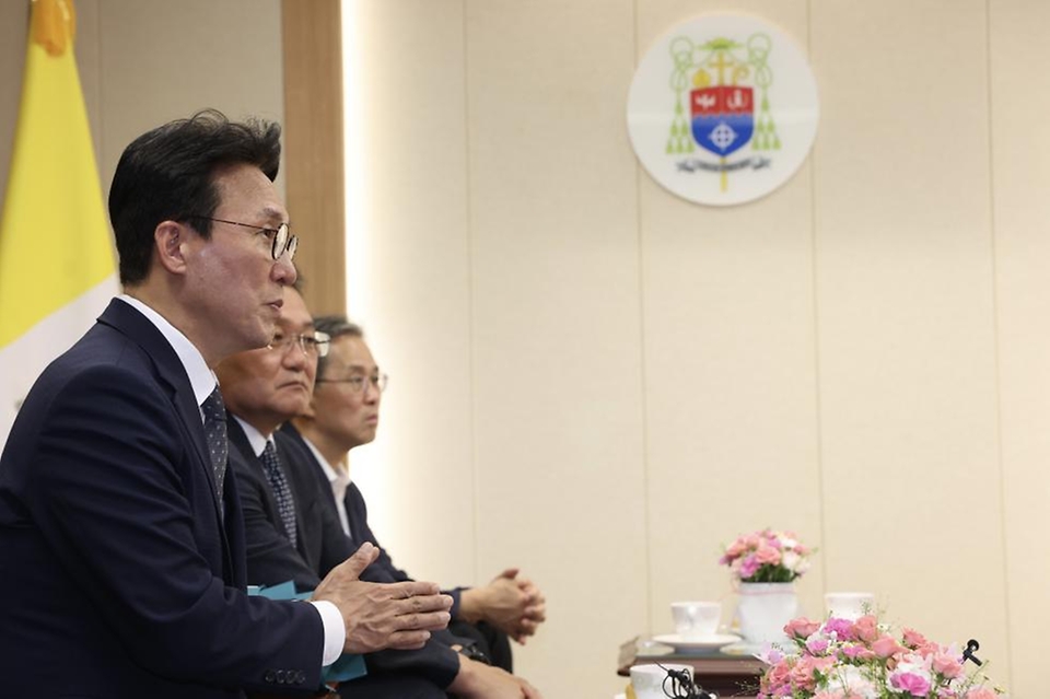 김민석 국무총리가 10일 경기 수원시 천주교수원교구청에서 한국천주교주교회의 의장인 이용훈 주교를 예방, 꽃다발을 들고 기념 촬영하고 있다.