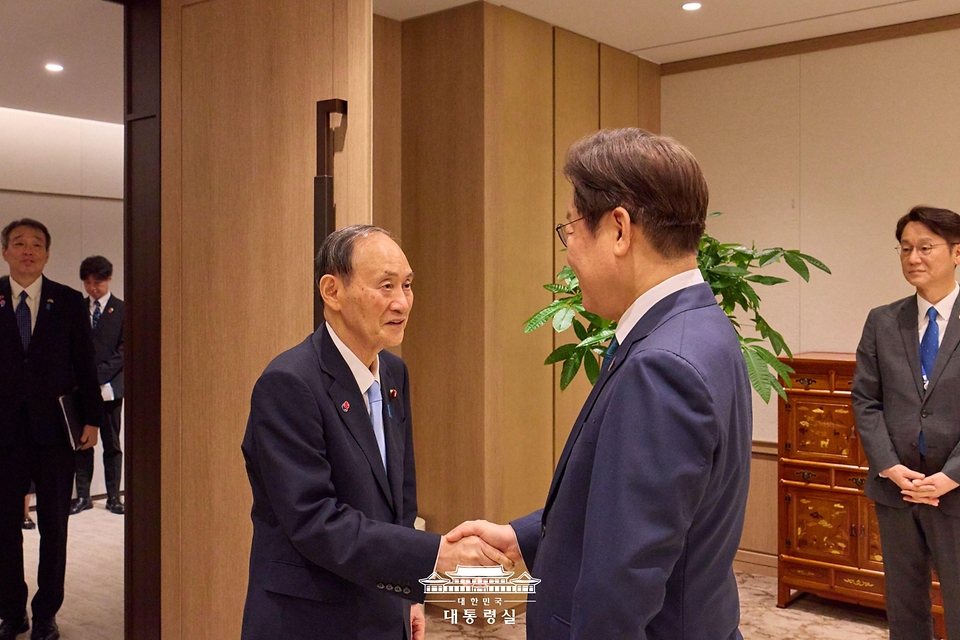 이재명 대통령이 30일 서울 용산 대통령실 청사에서 일한의원연맹 대표단을 접견하며 연맹 회장인 스가 요시히데 전 일본 총리와 악수하고 있다.