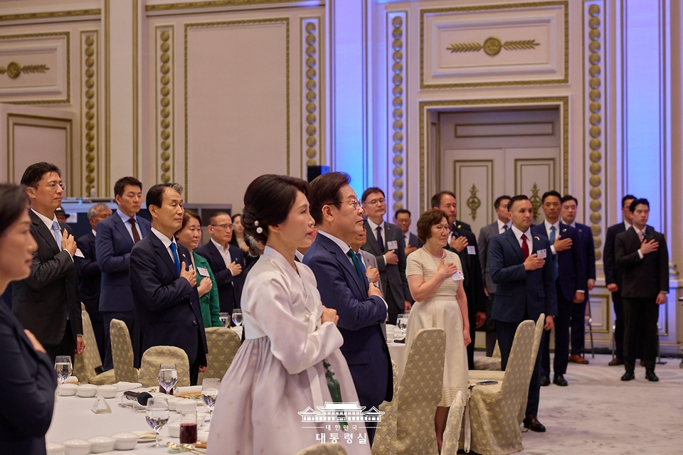 이재명 대통령과 김혜경 여사가 14일 청와대 영빈관에서 열린 '광복 80주년, 대통령의 초대' 행사에서 참석자들과 국기에 경례하고 있다.