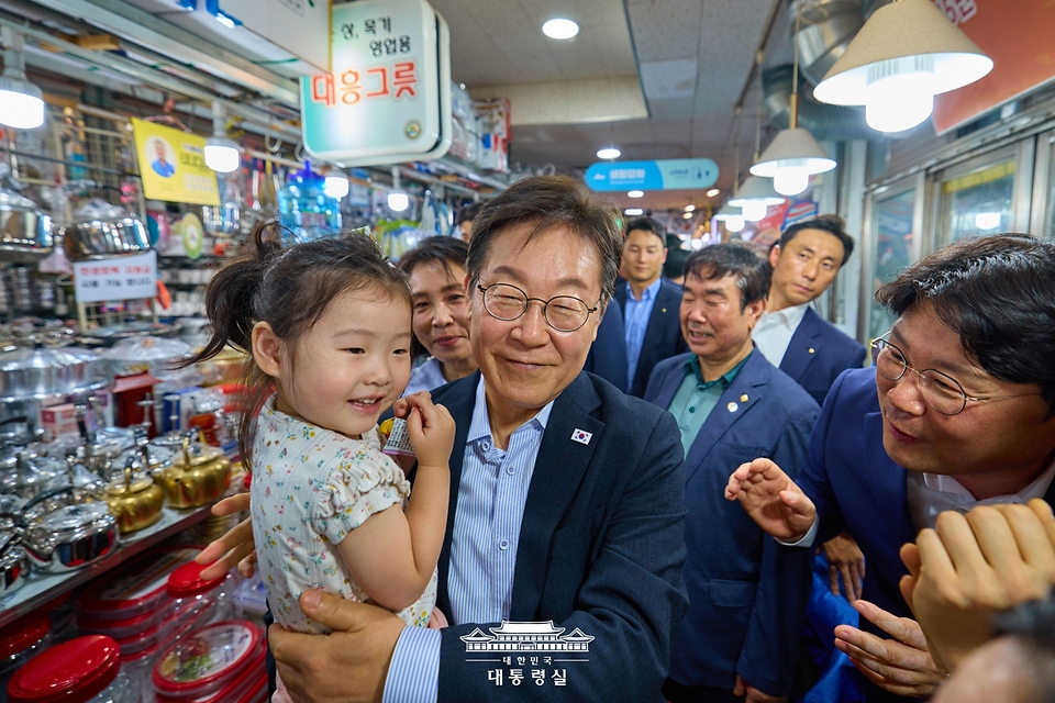 이재명 대통령이 17일 서울 은평구 연서시장을 방문해 어린이를 안아보고 있다.
