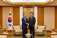 이재명 대통령이 24일 일본 도쿄의 한 호텔에서 일한의원연맹 회장인 스가 요시히데 전 일본 총리를 만나 인사하고 있다.