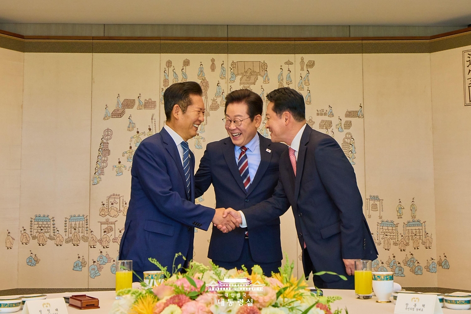 이재명 대통령이 8일 용산 대통령실에서 열린 여·야 지도부 오찬 회동에 앞서 정청래 더불어민주당 대표와 장동혁 국민의힘 대표의 악수 모습을 보며 밝게 웃고 있다.
