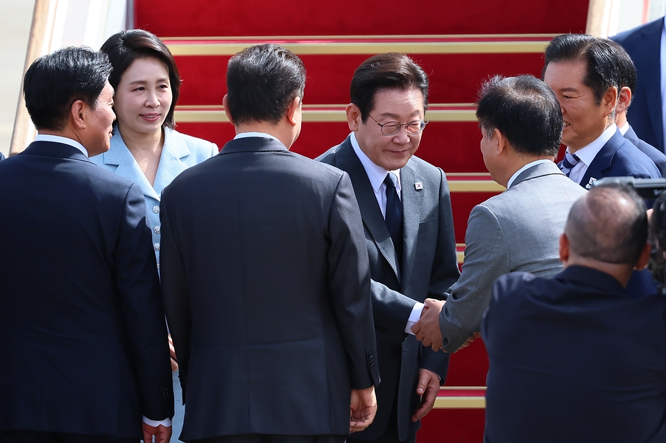 유엔총회에 참석하기 위해 출국하는 이재명 대통령과 김혜경 여사가 22일 경기도 성남 서울공항 공군 1호기에서 인사하고 있다.