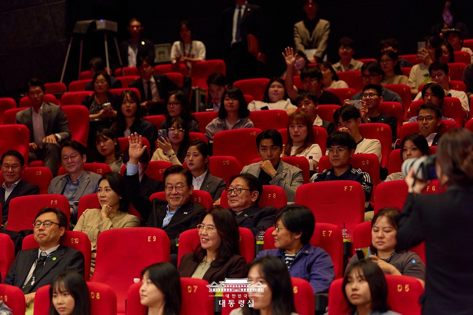 이재명 대통령이 20일 부산 해운대구 영화의전당에서 부산국제영화제 공식상영작 '극장의 시간들'을 관람한 뒤 감독과 배우에게 질문하기 위해 손을 들고 있다.