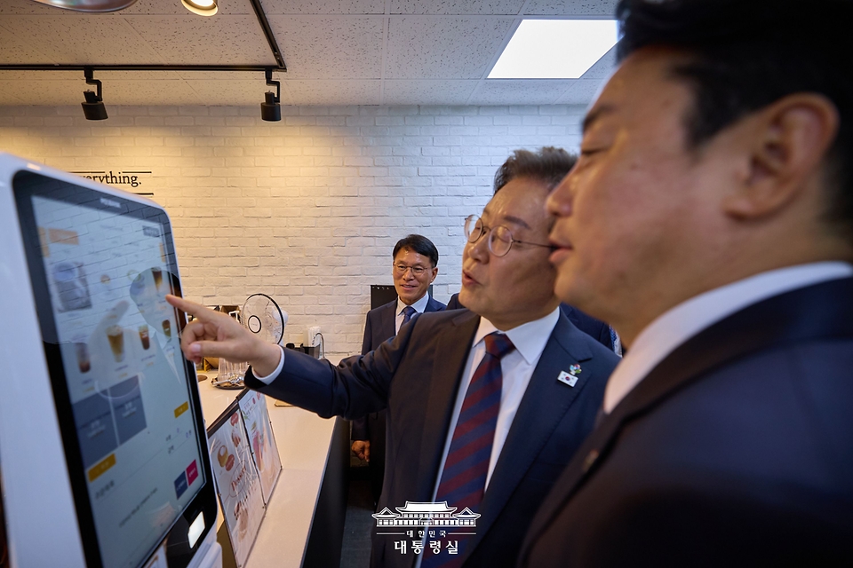 이재명 대통령이 10일 서울 용산 대통령실 청사 직원식당에서 점심 식사를 한 뒤 구내 매점을 방문해 커피를 주문하고 있다.
