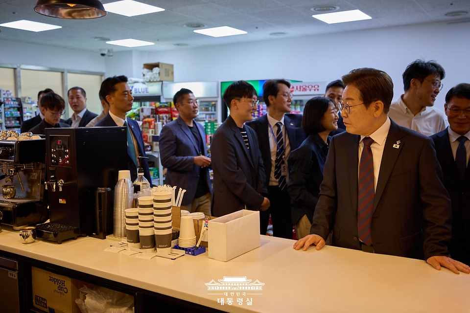 이재명 대통령이 10일 서울 용산 대통령실 청사 직원식당에서 점심 식사를 한 뒤 구내 매점을 방문해 커피를 주문하고 있다.