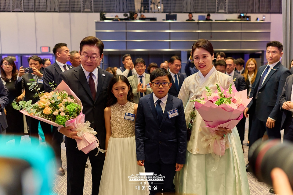 이재명 대통령과 김혜경 여사가 22일(현지시간) 미국 뉴욕의 한 호텔에서 열린 동포 간담회에서 화동들의 꽃다발을 받고 기념촬영을 하고 있다.