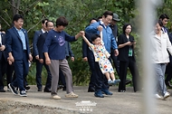 이재명 대통령이 16일 세종시 전동면 조일농원에서 박성호 조일농원 대표 가족의 손을 잡고 청년 농업인 간담회장으로 이동하고 있다.