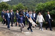 이재명 대통령이 16일 세종시 전동면 조일농원에서 박성호 조일농원 대표 가족의 손을 잡고 청년 농업인 간담회장으로 이동하고 있다.