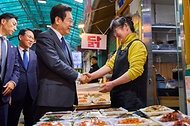 이재명 대통령이 20일 경기도 고양시 일산서구 일산시장을 찾아 상인들과 인사를 나누고 있다.