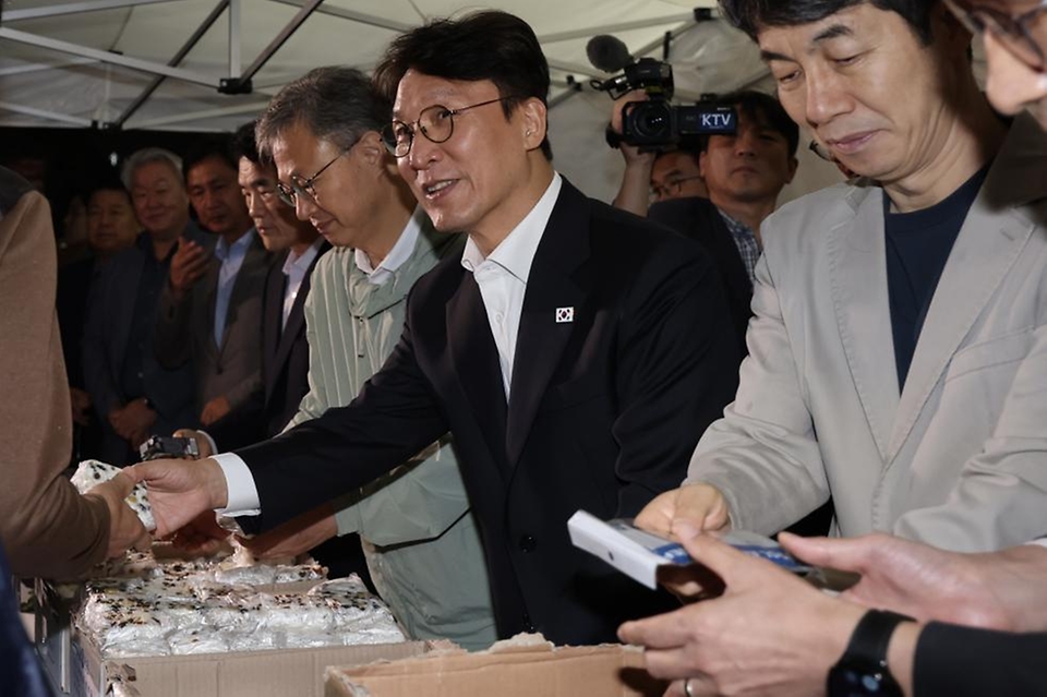 김민석 국무총리가 10일 구로구 남구로 새벽인력시장을 찾아 '종합지원 이동 상담버스'를 둘러보고 근로자들에게 떡을 나눠주고 있다.