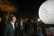 김민석 국무총리가 23일 경상북도 경주시 보문단지 호반 광장에 설치된 신라의 탄생 신화인 '알에서 태어난 혁거세'를 모티브로 제작한 높이 15m의 대형 알 모양의 APEC 상징조형물에 미디어아트가 진행되는 것을 살펴보고 있다.