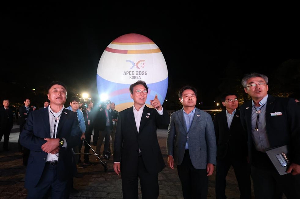 김민석 국무총리가 23일 경상북도 경주시 보문단지 호반 광장에 설치된 신라의 탄생 신화인 '알에서 태어난 혁거세'를 모티브로 제작한 높이 15m의 대형 알 모양의 APEC 상징조형물에 미디어아트가 진행되는 것을 살펴보고 있다.