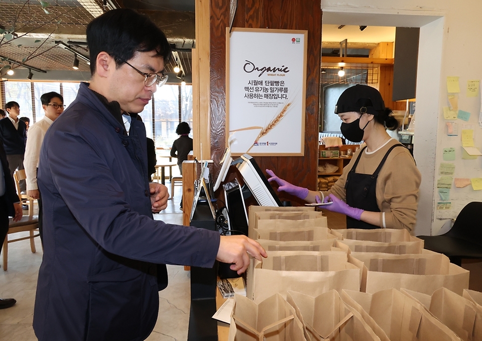 김민재 행정안전부 차관이 3일 오전 경북 안동시의 한 상점을 방문하여 '코리아 그랜드 페스티벌'과 관련해 지역 소상공인을 격려하고 지역 상품을 구매하고 있다.