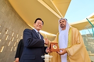 이재명 대통령이 17일(현지시간) UAE 현충원인 '와하트 알 카리마'를 방문해 디얍 대통령 직속 개발·보훈 사무국 부의장으로부터 기념메달을 받은 뒤 악수하고 있다.