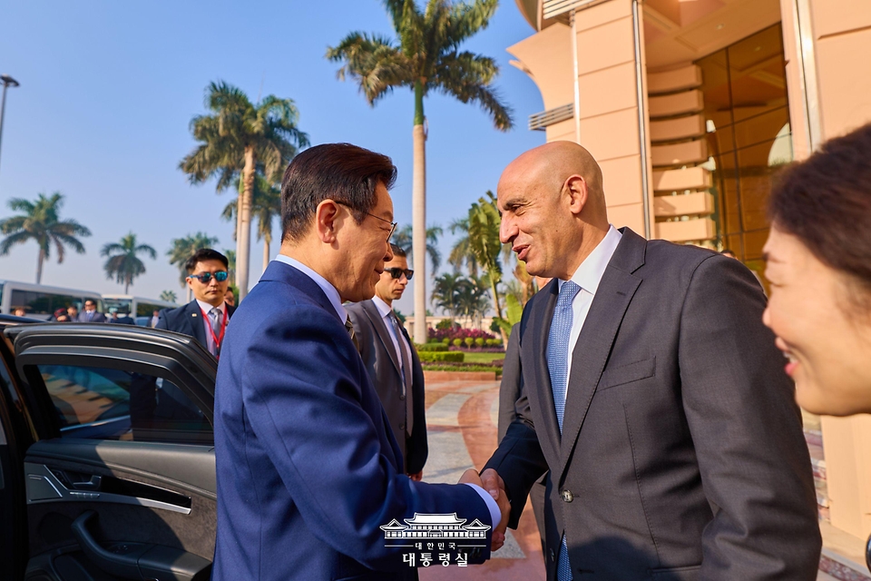 이집트 공식 방문 일정을 마친 이재명 대통령이 21일(현지시간) 카이로 국제공항에서 남아프리카공화국 요하네스버그로 출발하기 전 환송인사와 악수하고 있다. 