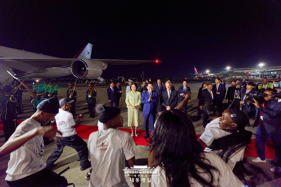 G20 정상회의에 참석하는 이재명 대통령과 김혜경 여사가 21일(현지시간) 남아프리카공화국 요하네스버그 O.R. 탐보 국제공항에 도착해 환영공연을 바라보고 있다. 